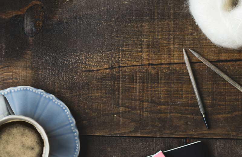 coffee and cup on a wooden backdrop with natural wool and materials